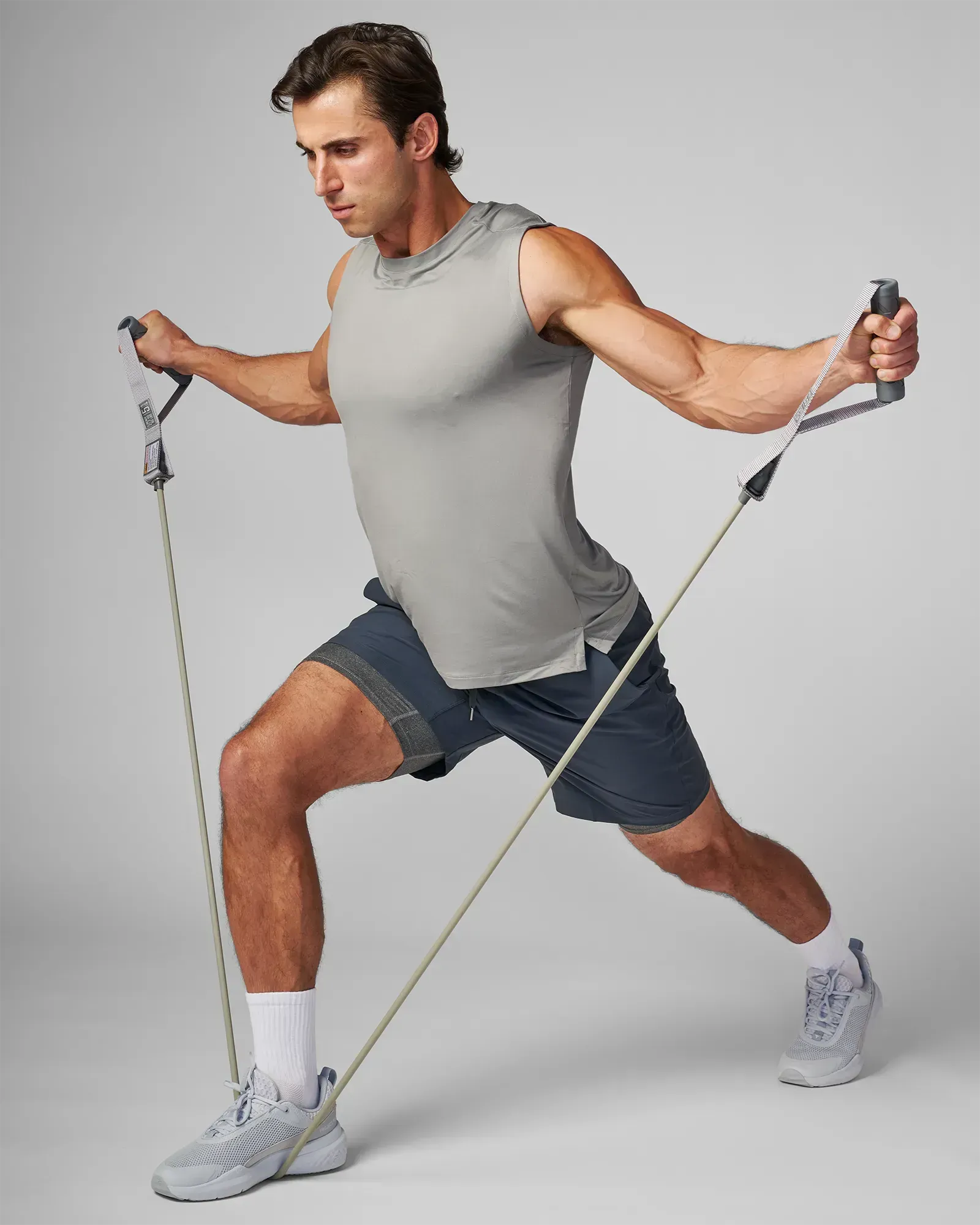 Man performing a lateral lunge with a bilateral lateral raise using EQYP Power Tubes with Handles Extra Heavy gray resistance tube