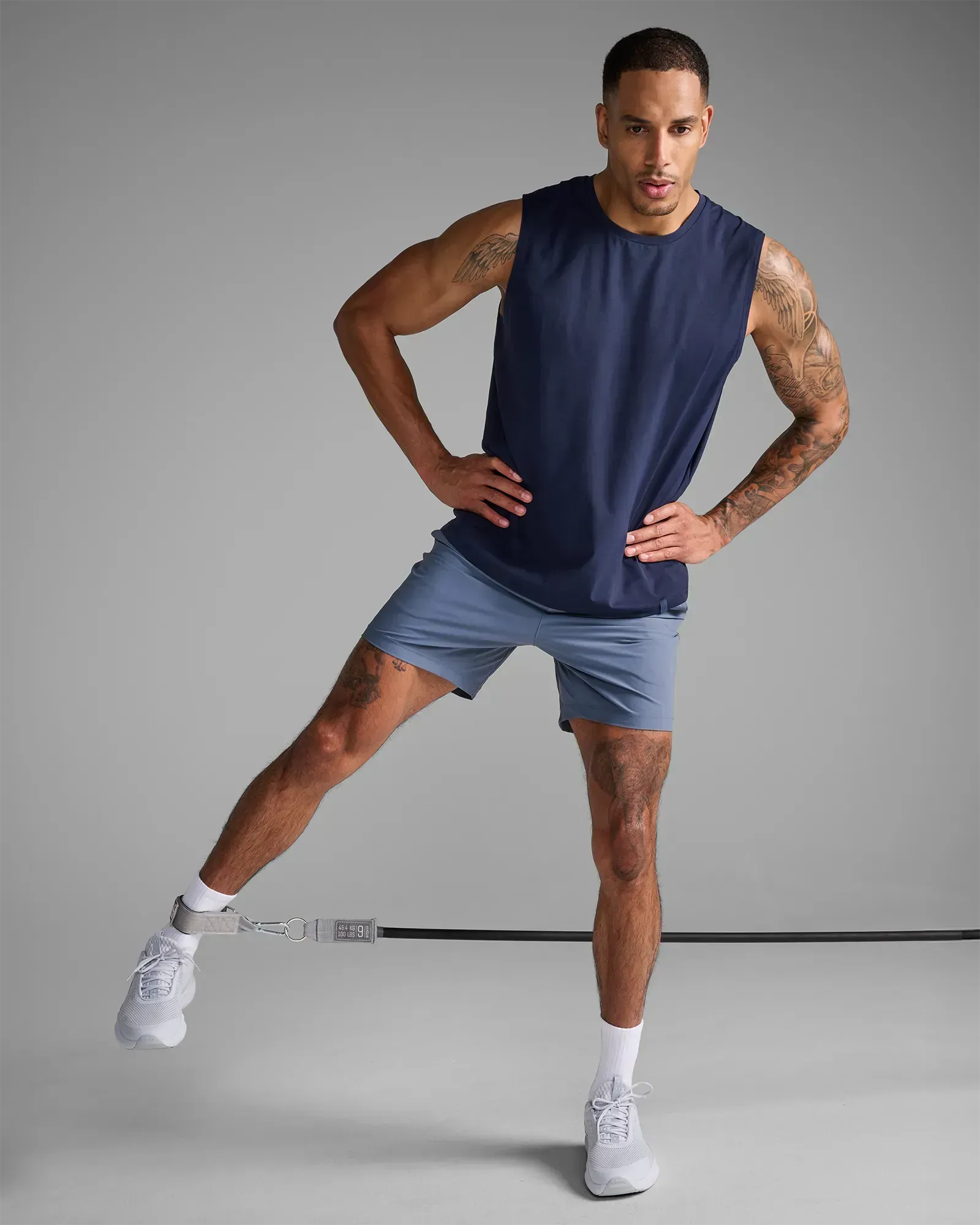 Man performing a standing lateral leg raise using EQYP Power Tubes 100 lbs black resistance tube with ankle strap attachment