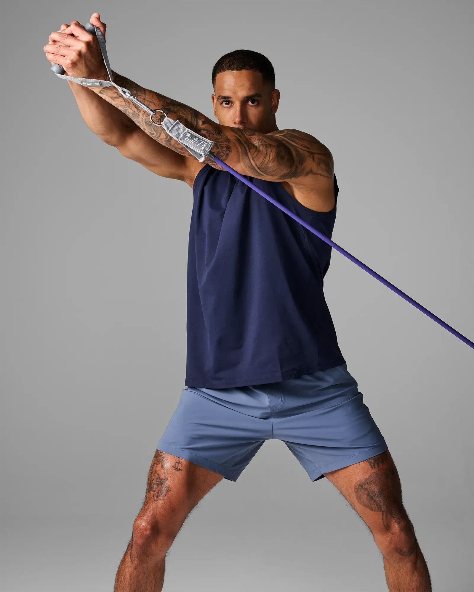 Man performing a standing diagonal wood chop using the EQYP Power Tubes Door Anchor with resistance tube