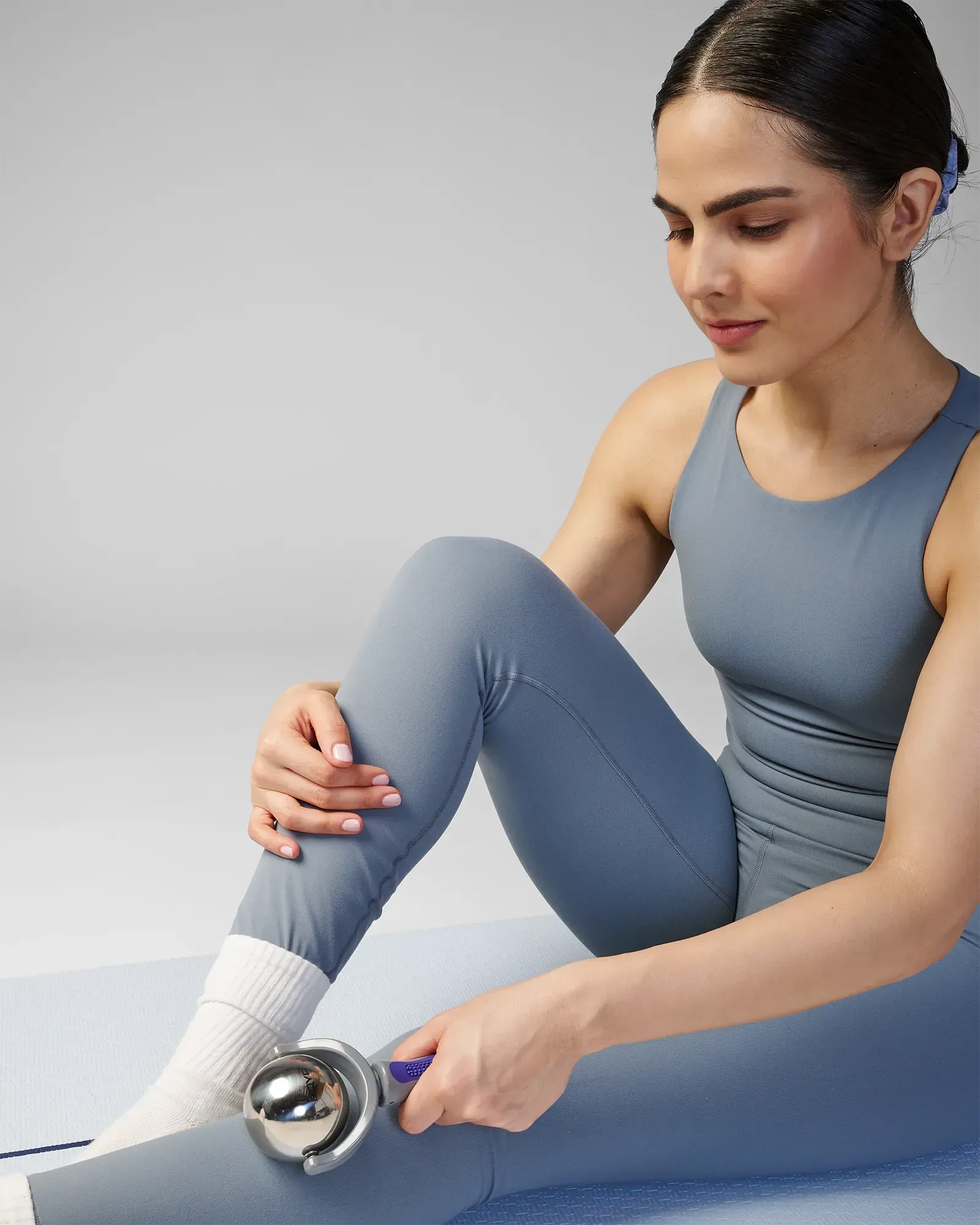 Woman using stainless steel core EQYP roller with easy-grip handle on leg