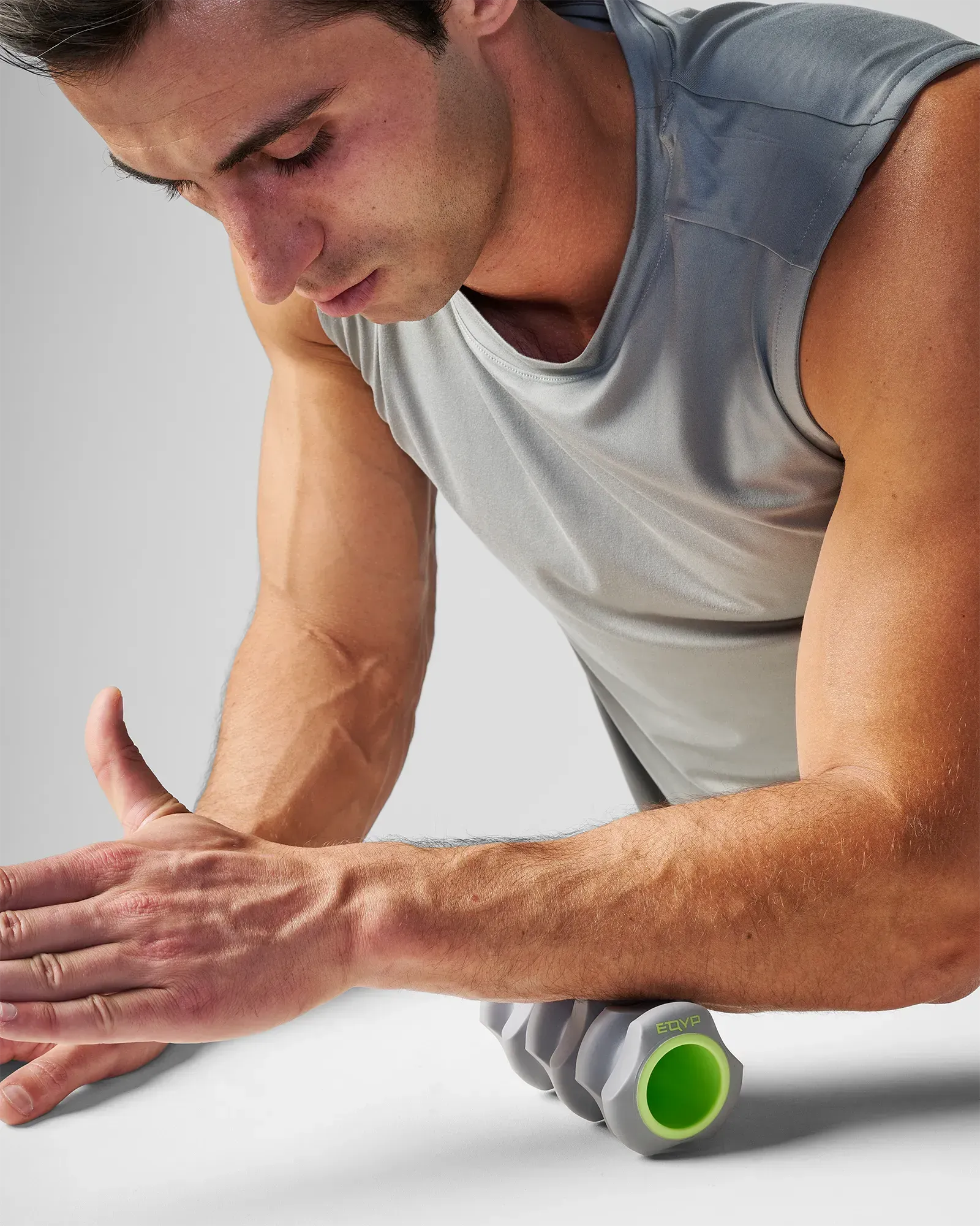 Man rolling EQYP Foot and Hand Roller along forearm to reduce muscle tightness and improve circulation in the lower arm