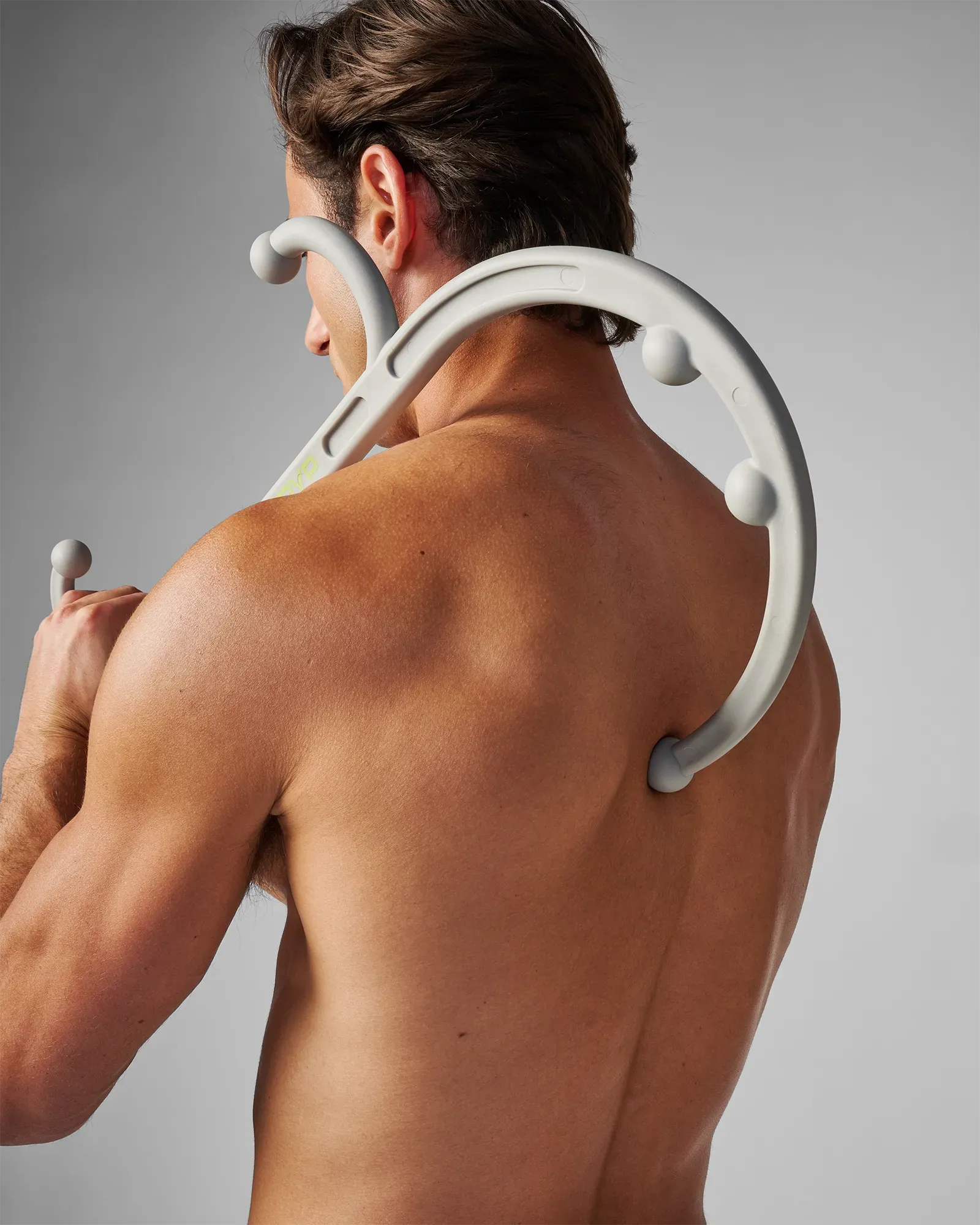 Man using EQYP muscle hook recovery massager tool on his upper back