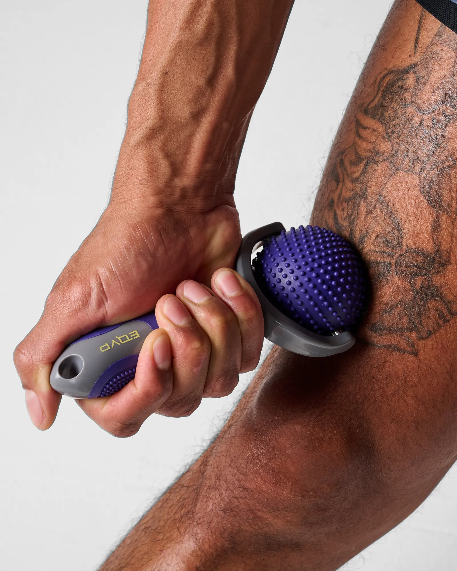 Man using EQYP massage roller on leg for muscle relief