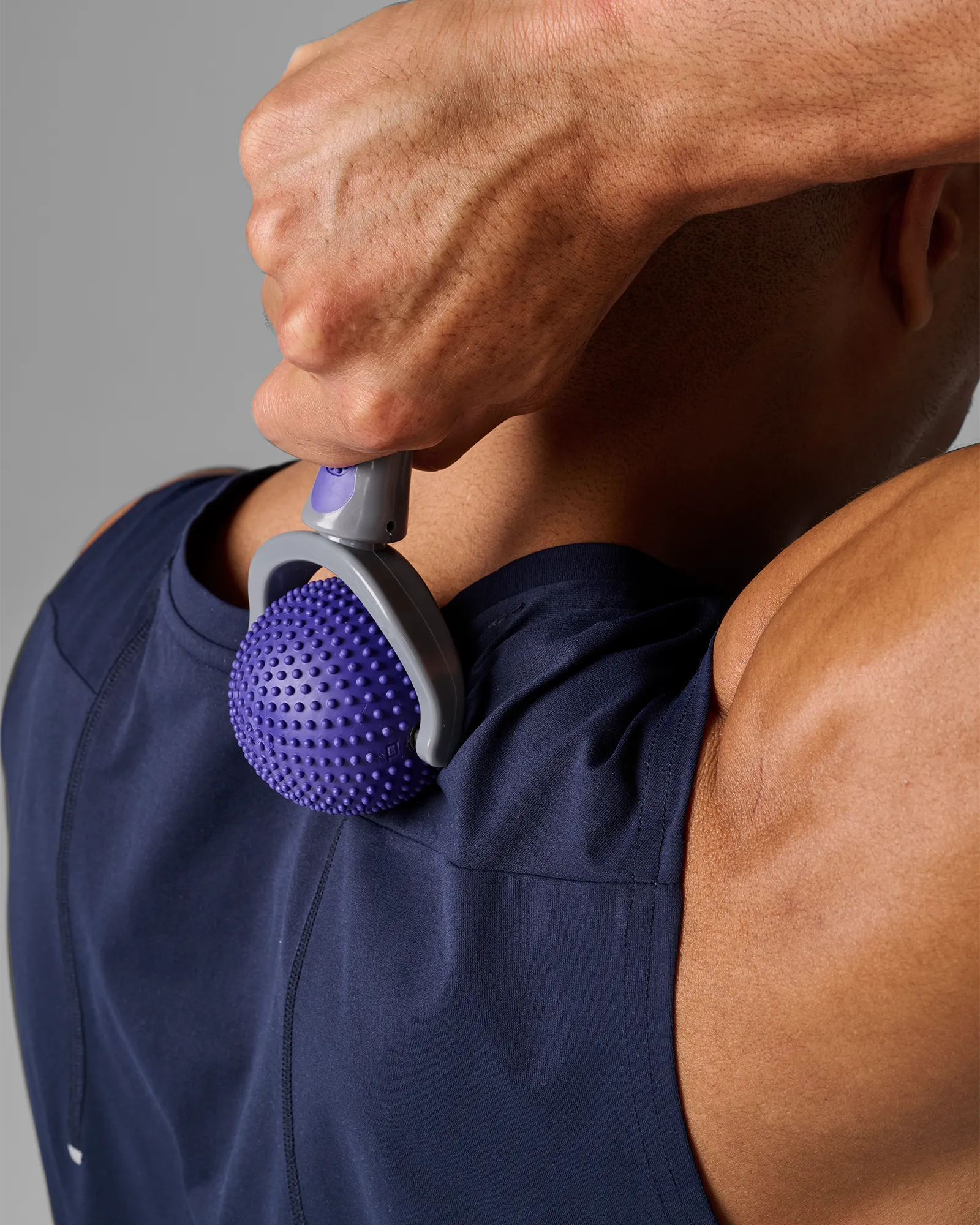 Man using EQYP massage roller on upper back for muscle relief