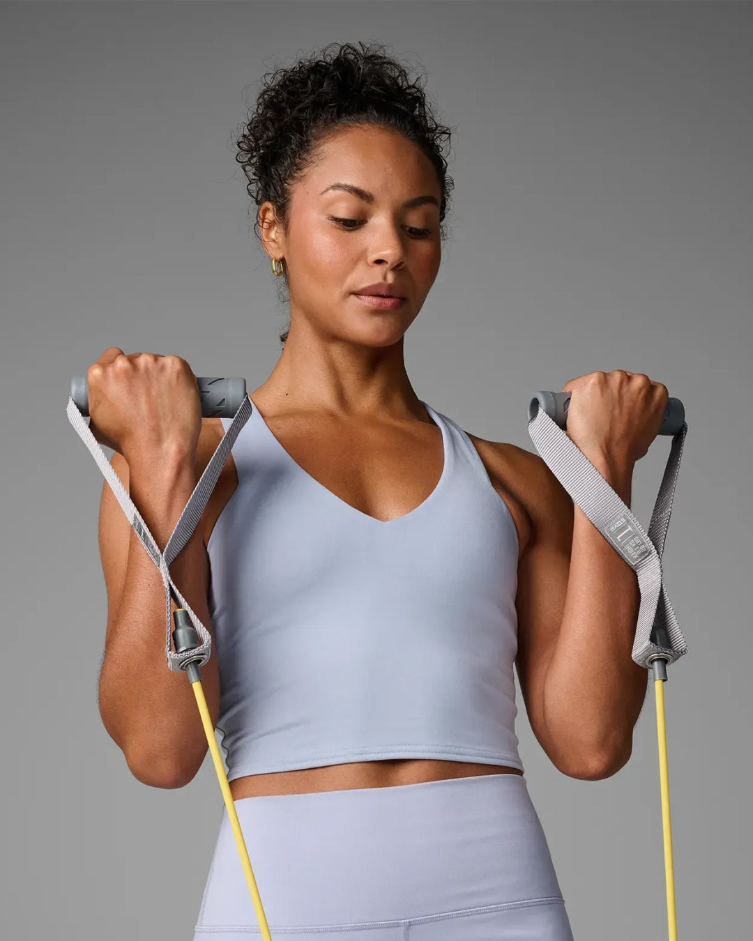 Woman performing a standing bicep curl using EQYP Power Tubes with Handles Extra Light