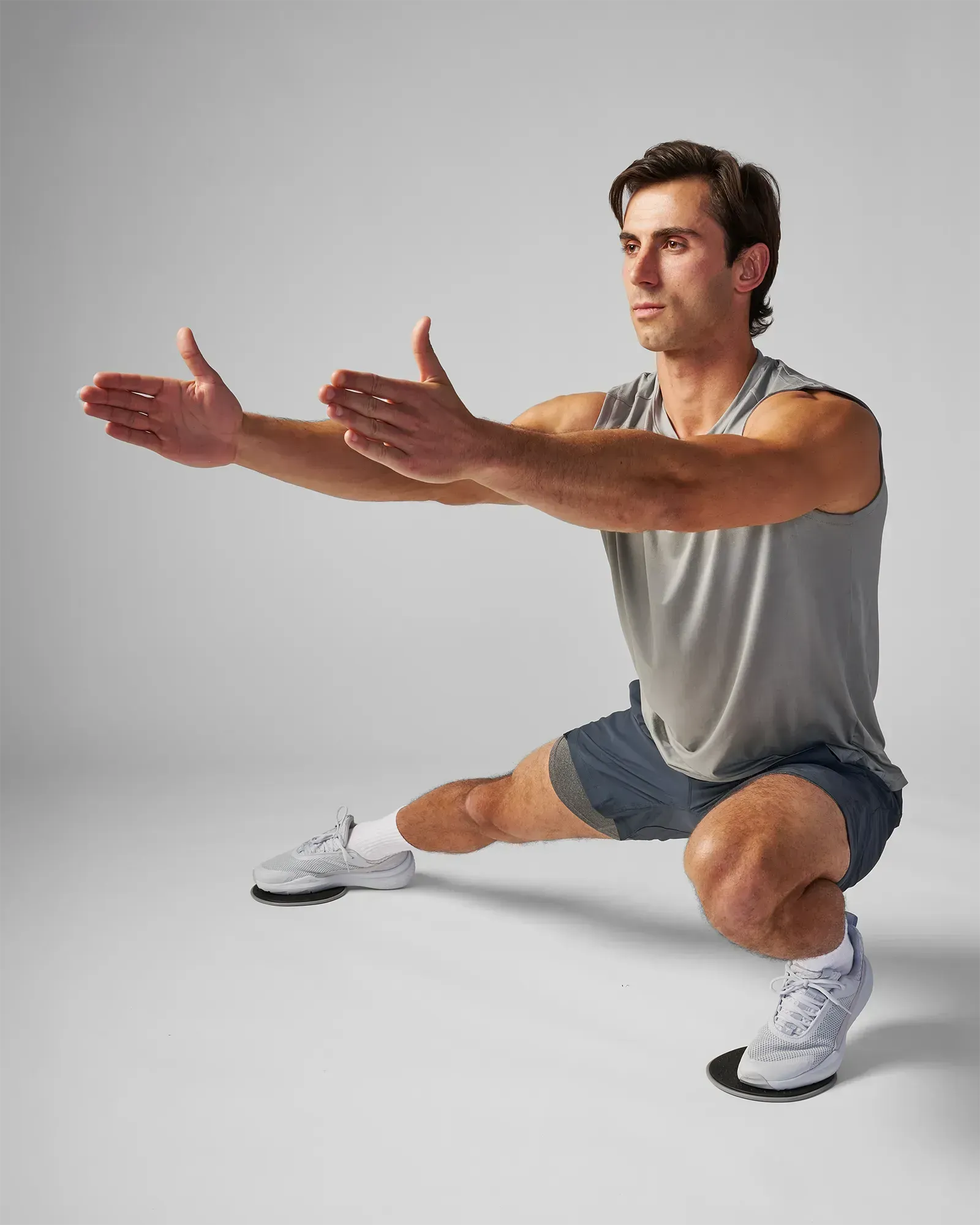 Man performing a sliding side lunge using EQYP Sliding Discs under both feet