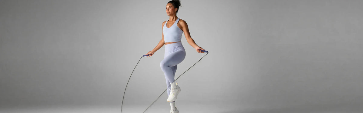 Woman mid-motion using a EQYP jump rope during a cardio workout.