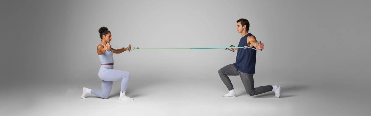 Man and woman facing each other in lunges, each pulling a EQYP Resistance Power Tube with Handles.