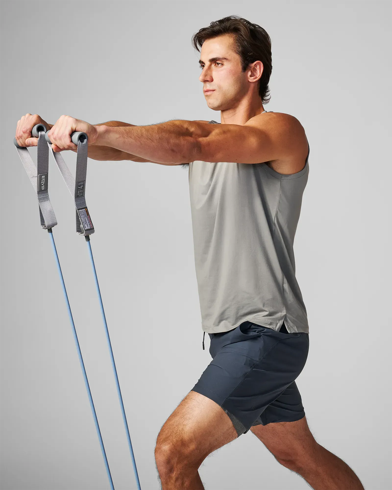 Man performing a standing bilateral front raise using EQYP Power Tubes with Handles Heavy blue resistance tube