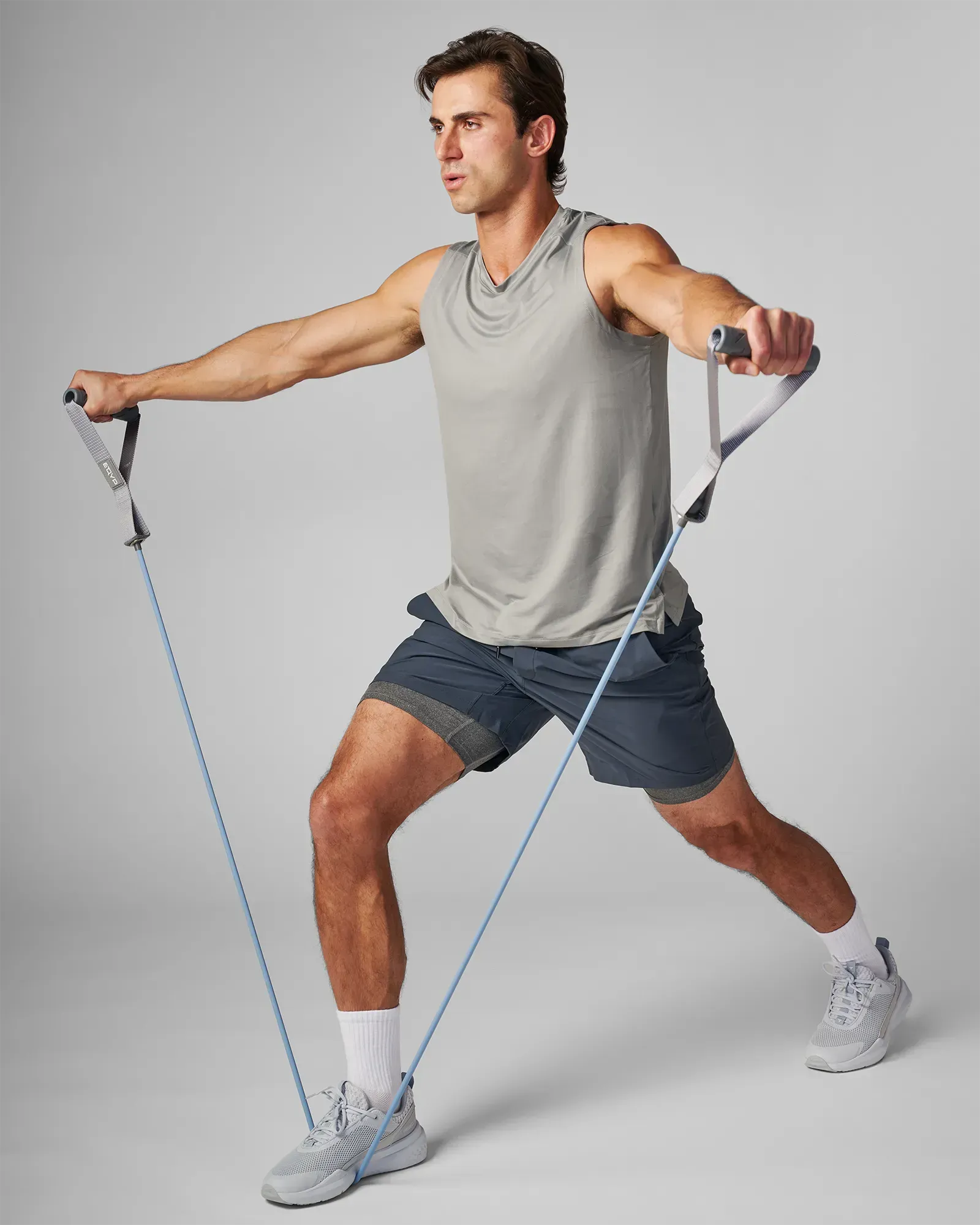 Man performing a lateral lunge with a bilateral lateral raise using EQYP Power Tubes with Handles Heavy blue resistance tube