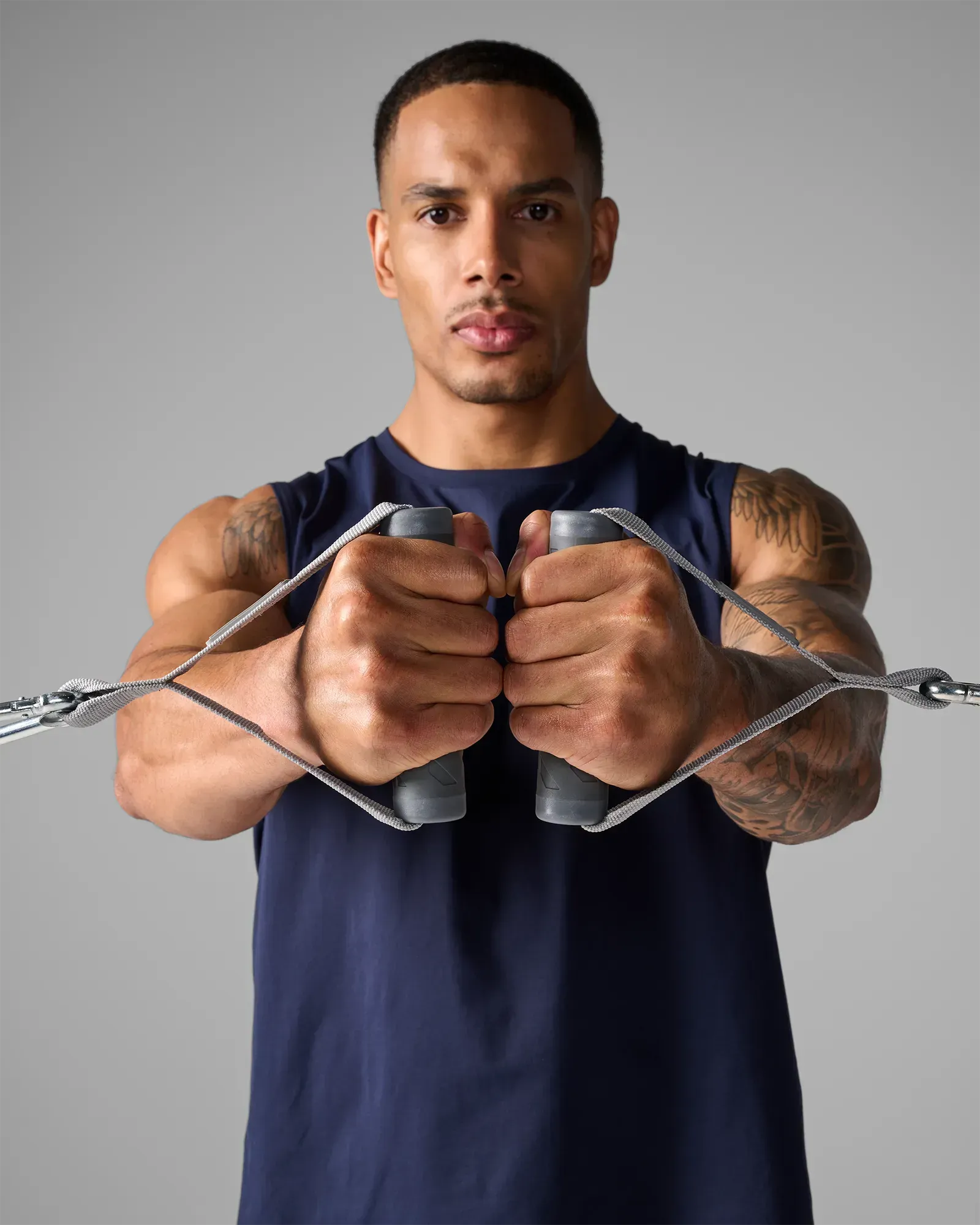 Man performing a standing chest press using EQYP Power Tubes Handles with resistance tubes