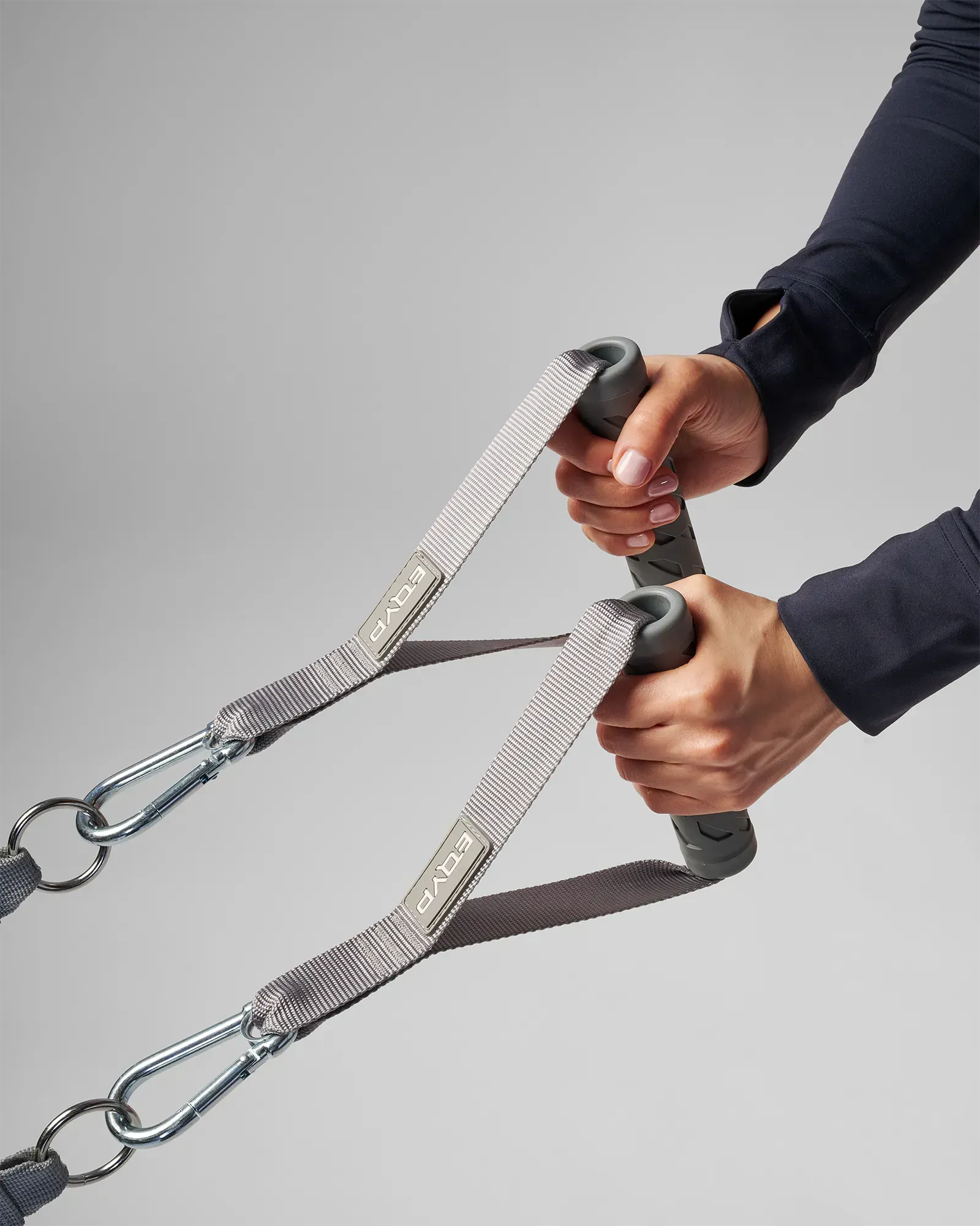 Hands gripping a pair of EQYP Power Tubes Handles with carabiner clips attached