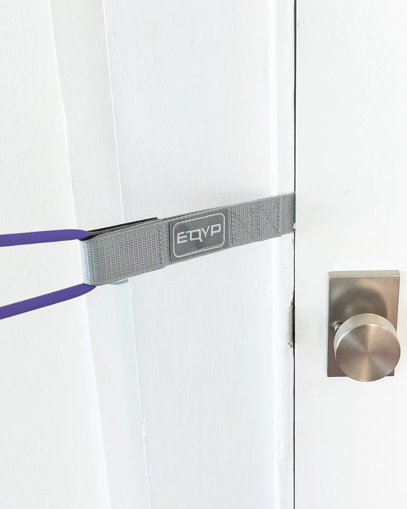 EQYP Power Tubes Door Anchor secured in a door frame at mid-height with resistance tube attached