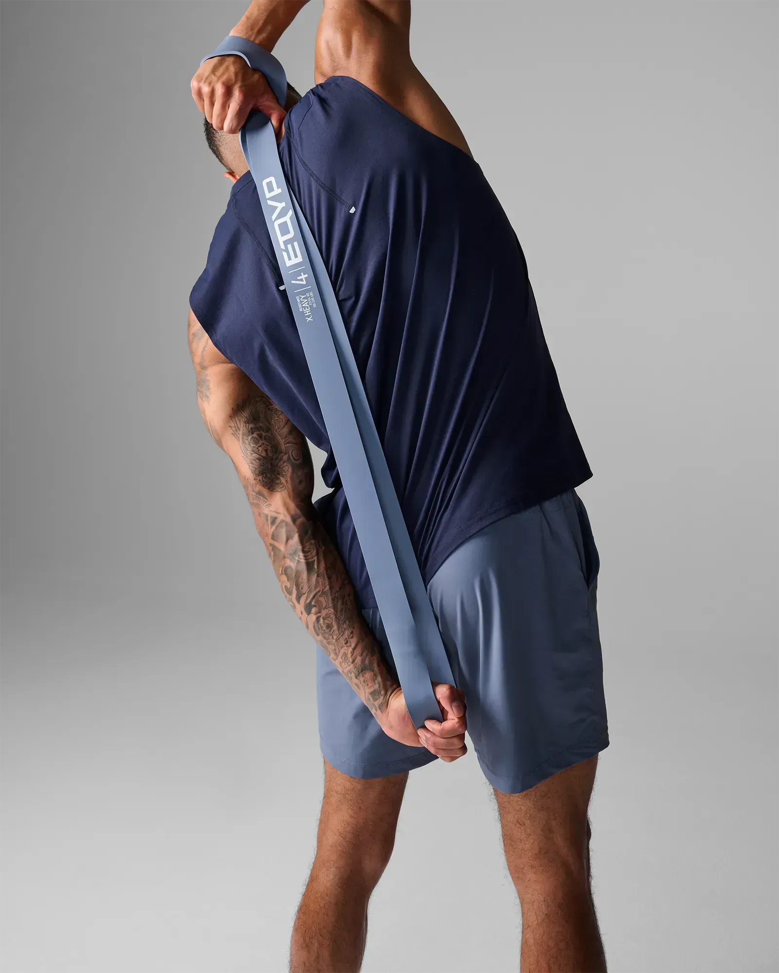 Man performing a stretch using an EQYP light gray elastic wide super band