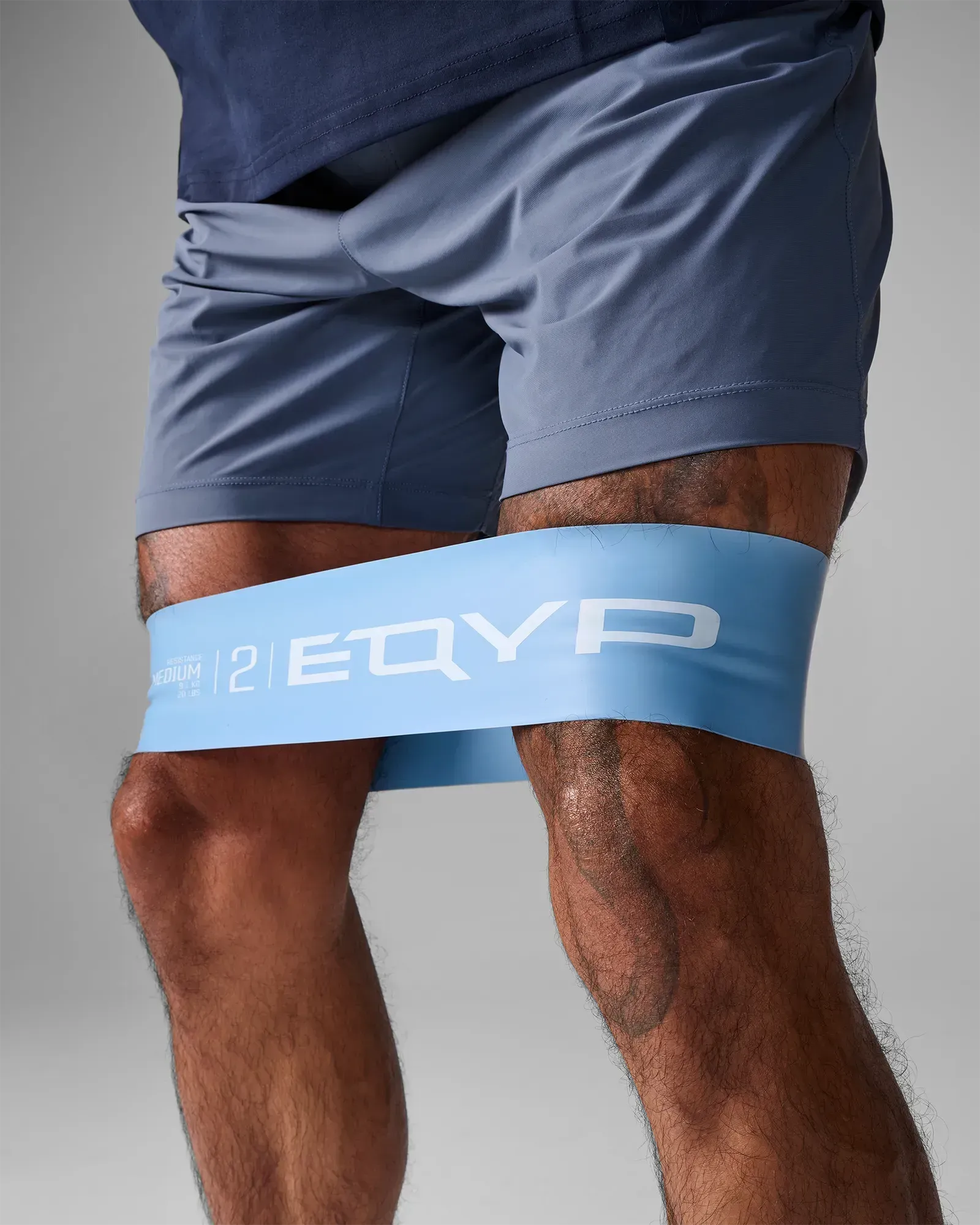 Close-up of EQYP Ultimate Power Loop Medium light blue resistance band worn above the knees