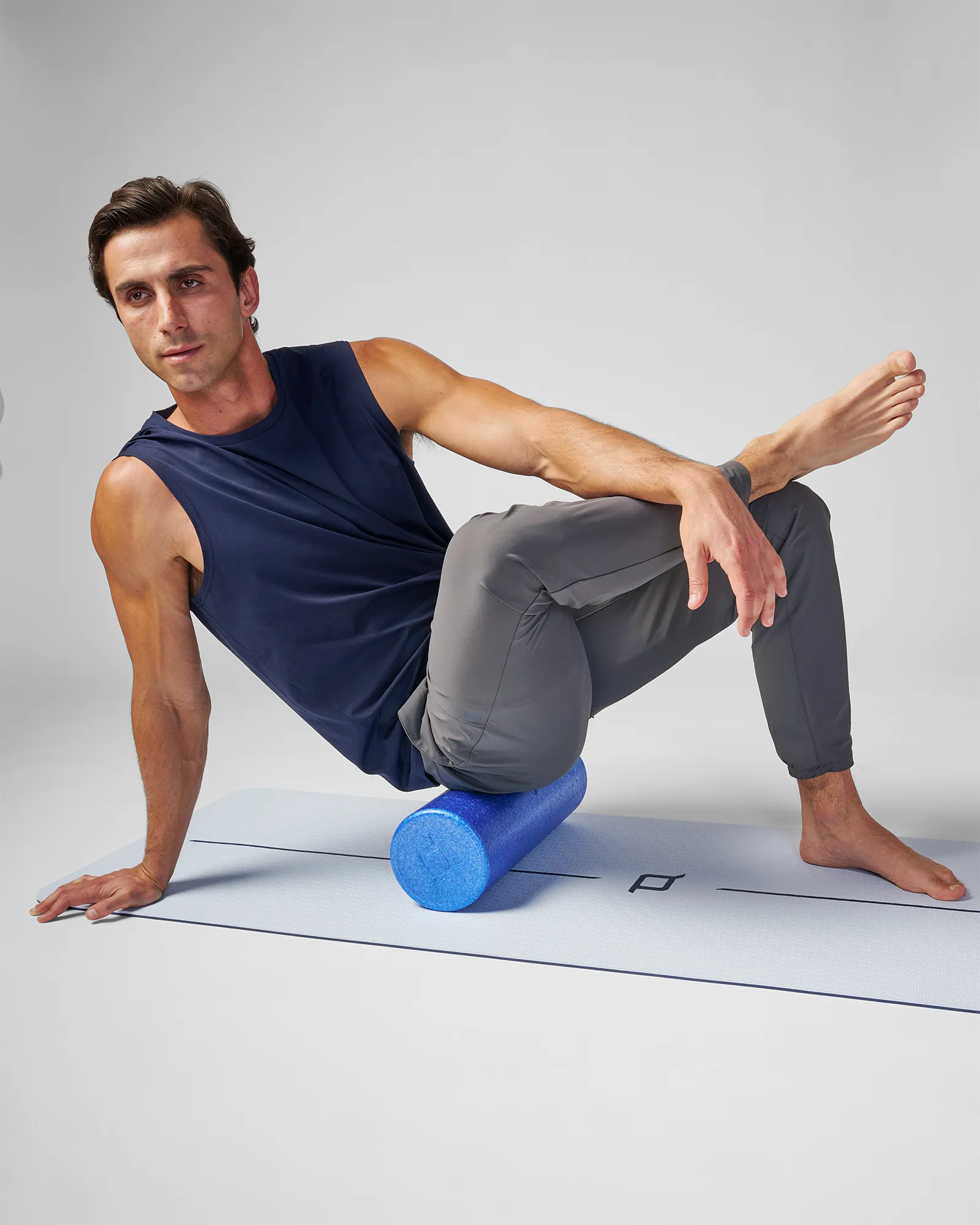 Man rolling EQYP 18 inch Smooth EPP Foam Roller along outer hip and IT band to relieve lateral leg tightness and improve mobility