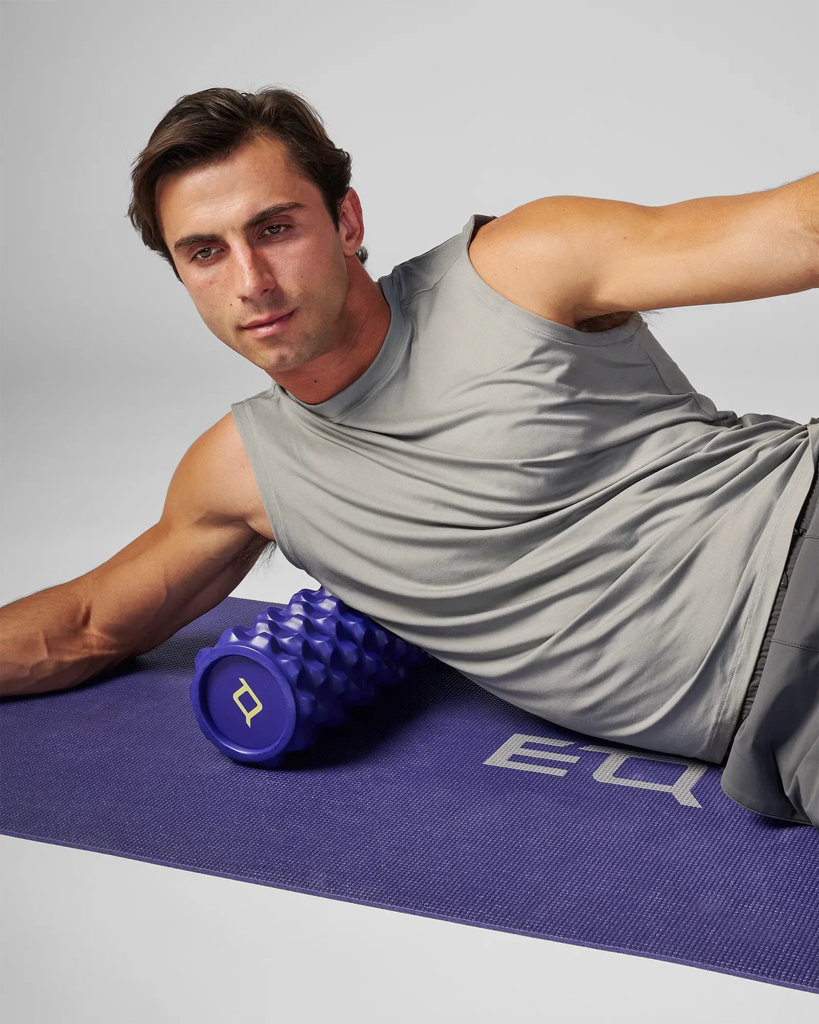 Man using extreme 18 Inch EQYP Foam Roller for upper body muscle recovery on exercise mat