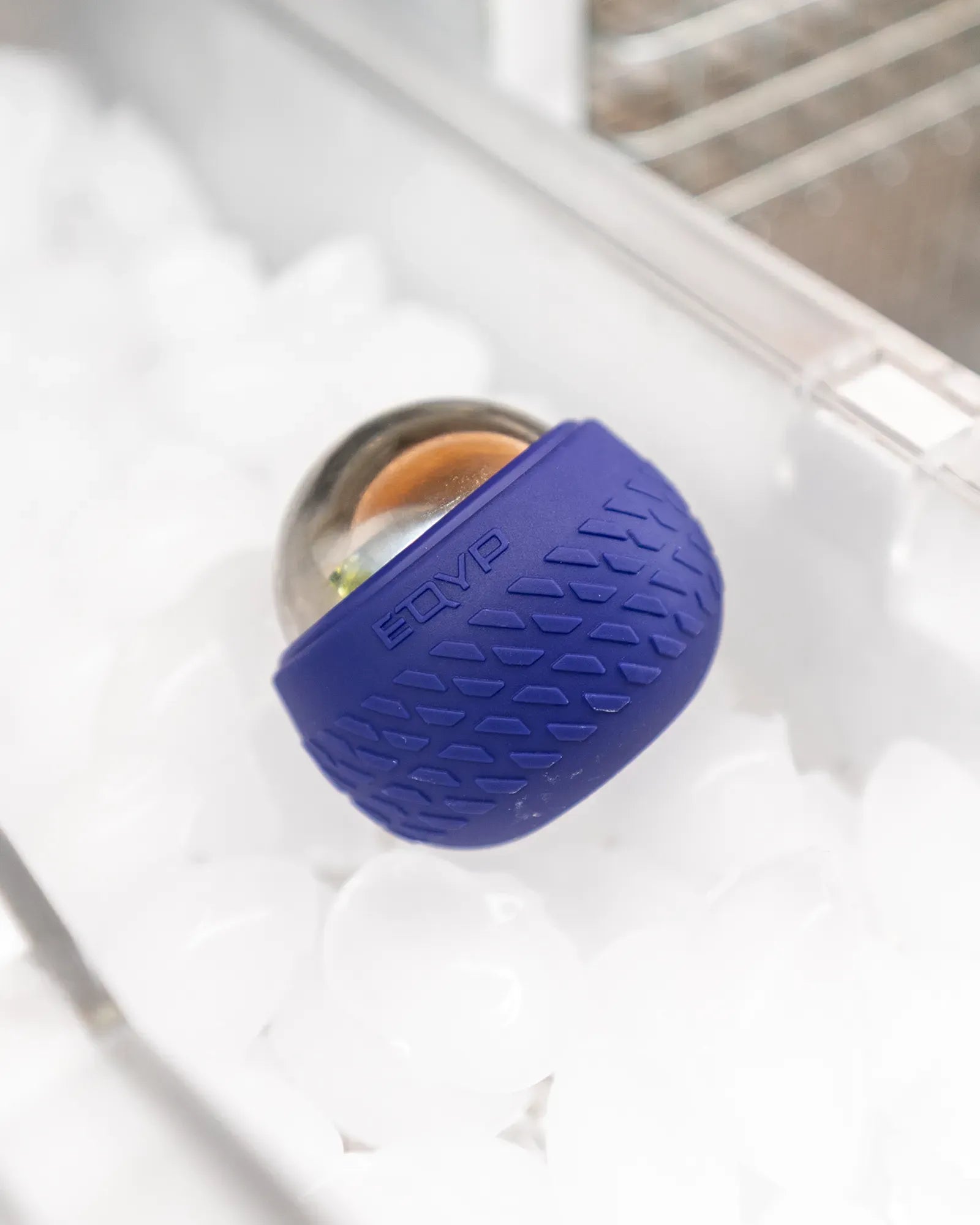 Stainless steel core EQYP roll-on massager with textured outer shell on ice