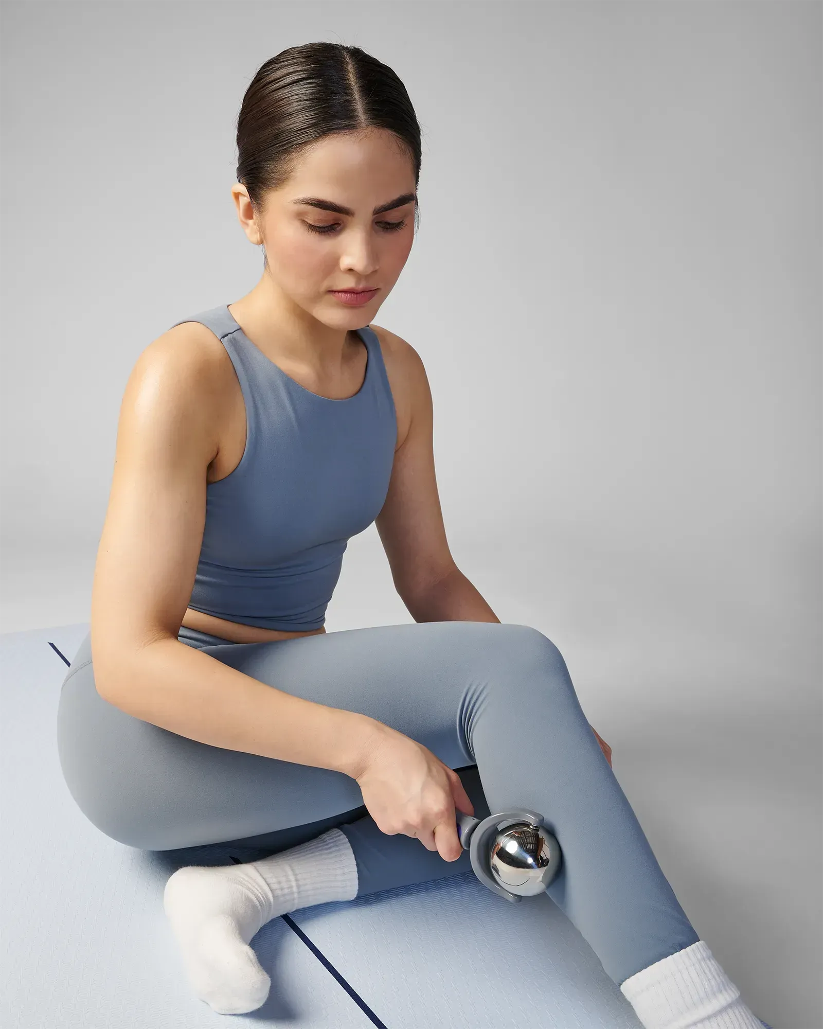 Woman using stainless steel core EQYP roller with easy-grip handle on calf