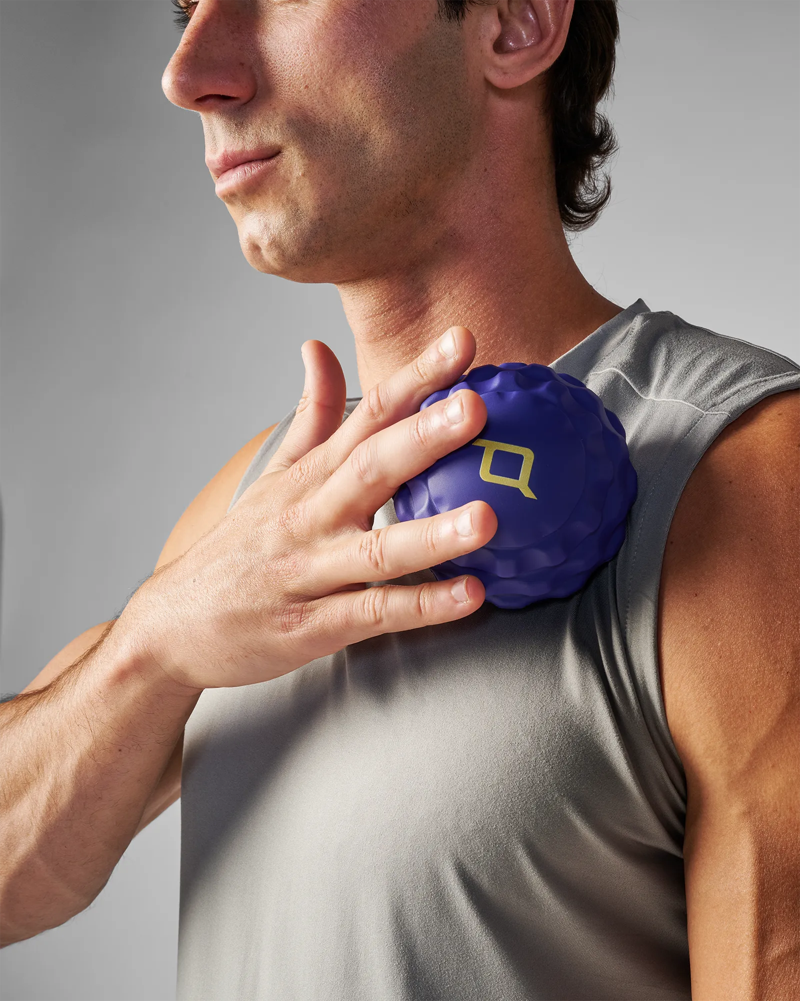 Person using medium sized blue EQYP massage ball on neck for pain relief
