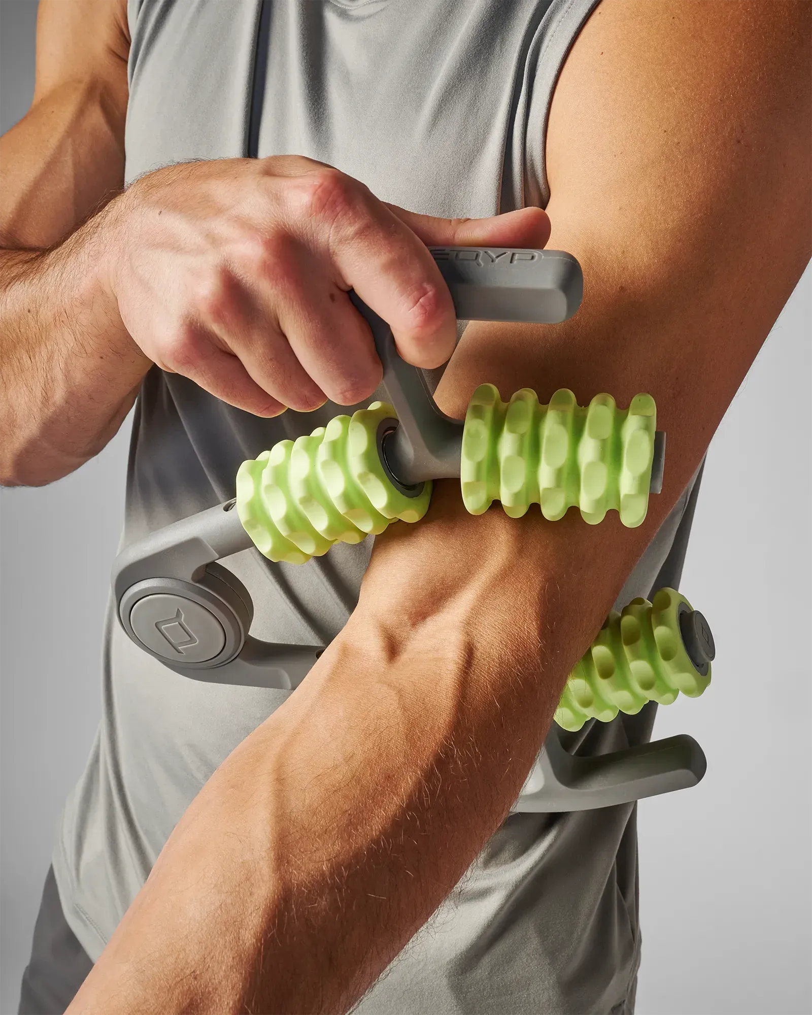 Man using muscle compressor with 4-point massage rollers on his arm