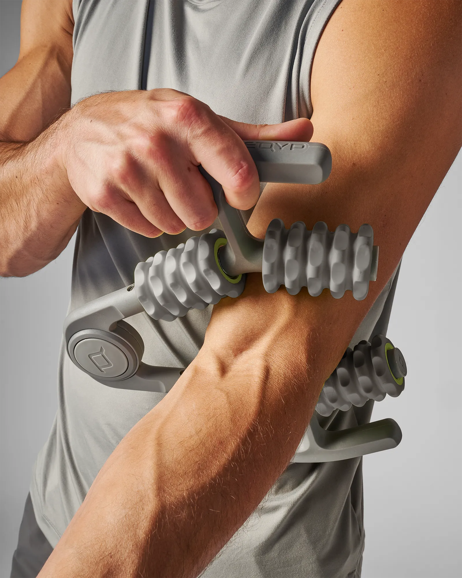 Man using muscle compressor with 4-point massage rollers on his arm