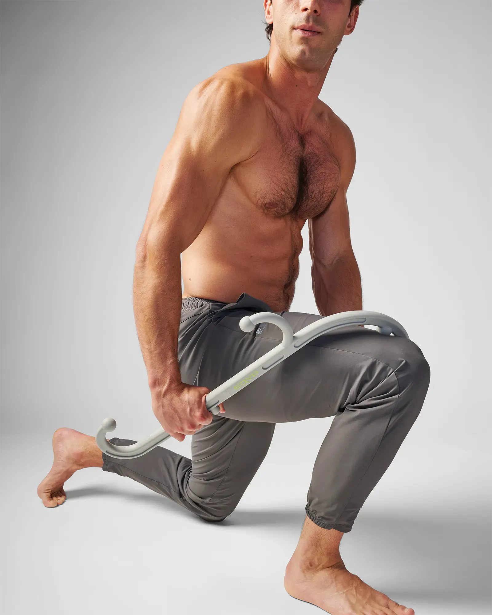 Man using EQYP muscle hook recovery massager tool on his leg