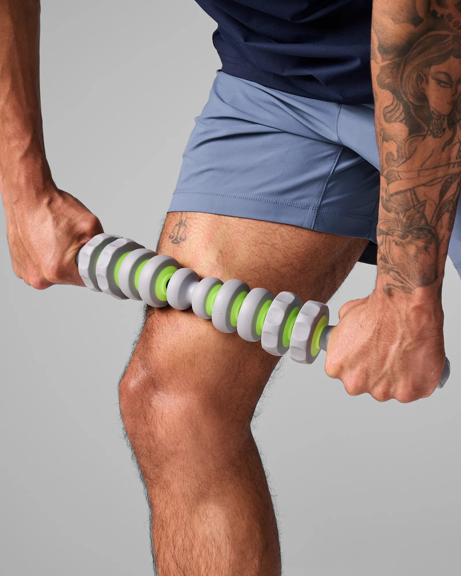 Man rolling EQYP 19 inch Massager Bar along hamstring to relieve posterior thigh tightness and improve range of motion