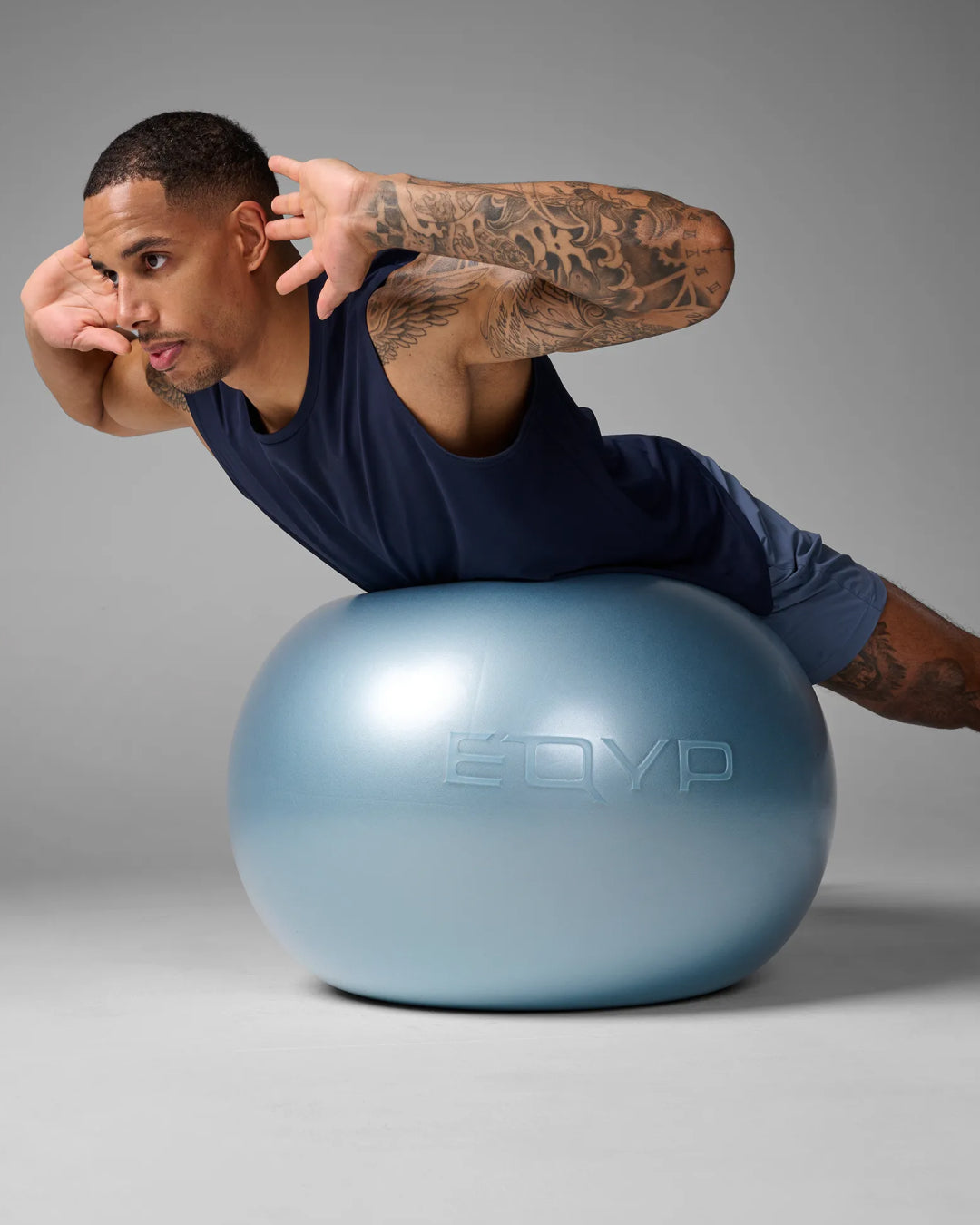 Man performing a stability ball oblique crunch on an EQYP Pro Stability Ball 65cm with hips supported on the ball