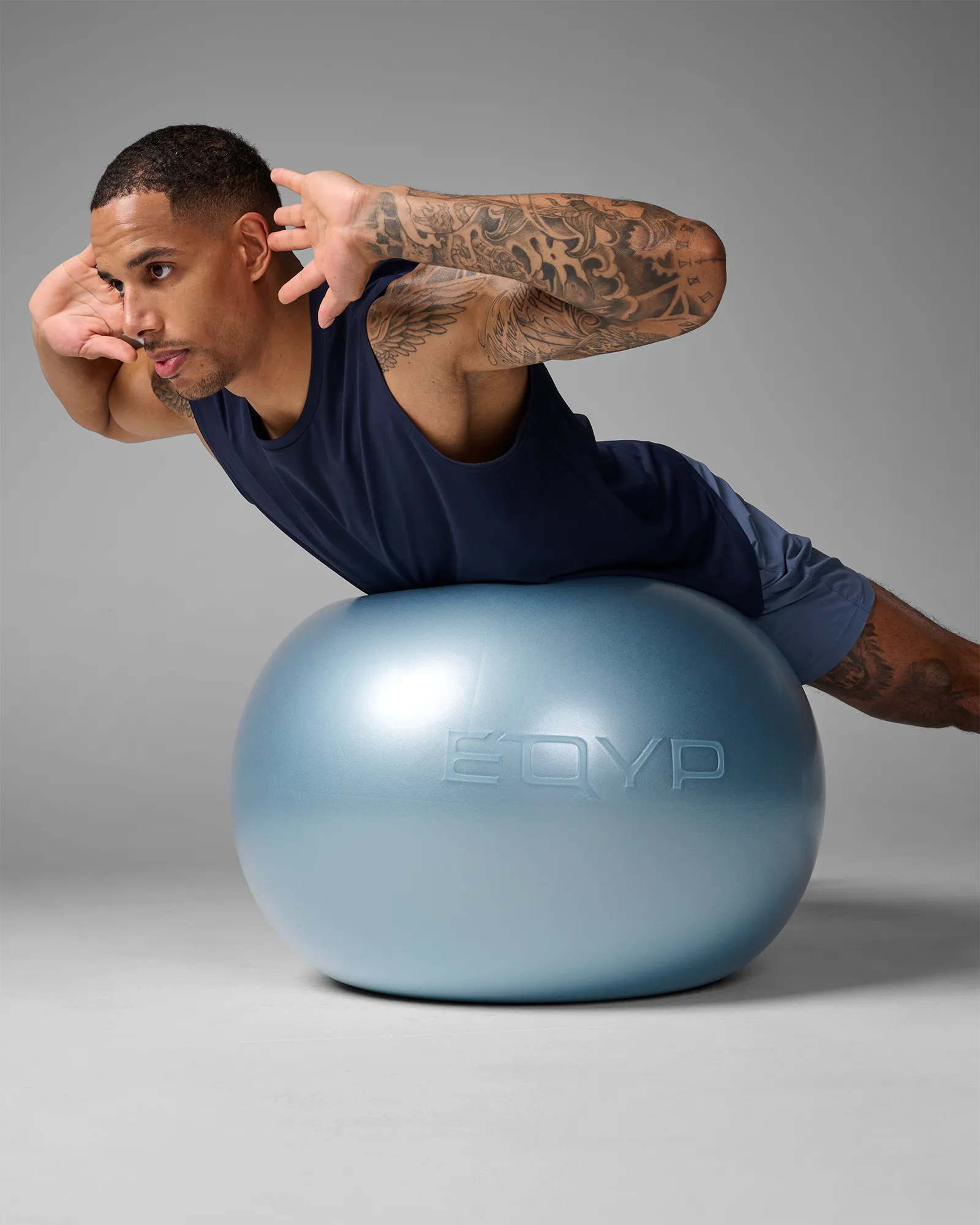 Man performing a stability ball oblique crunch on an EQYP Pro Stability Ball 65cm with hips supported on the ball